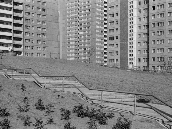 ein Hang umrahmt von Wohnblocks in schwarz-weiß