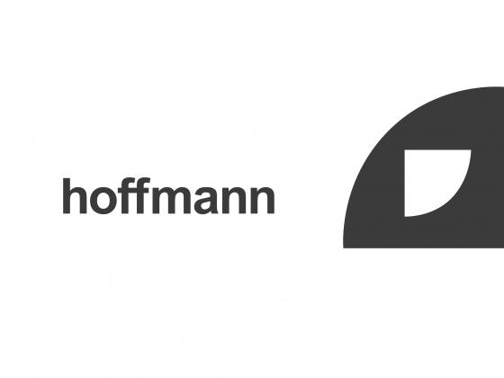 hoffmann is spelled out, lowercase in arial typeface on the lefthandside of a black quater circle with a smaller half cercle in white and oriented in the opposite direction