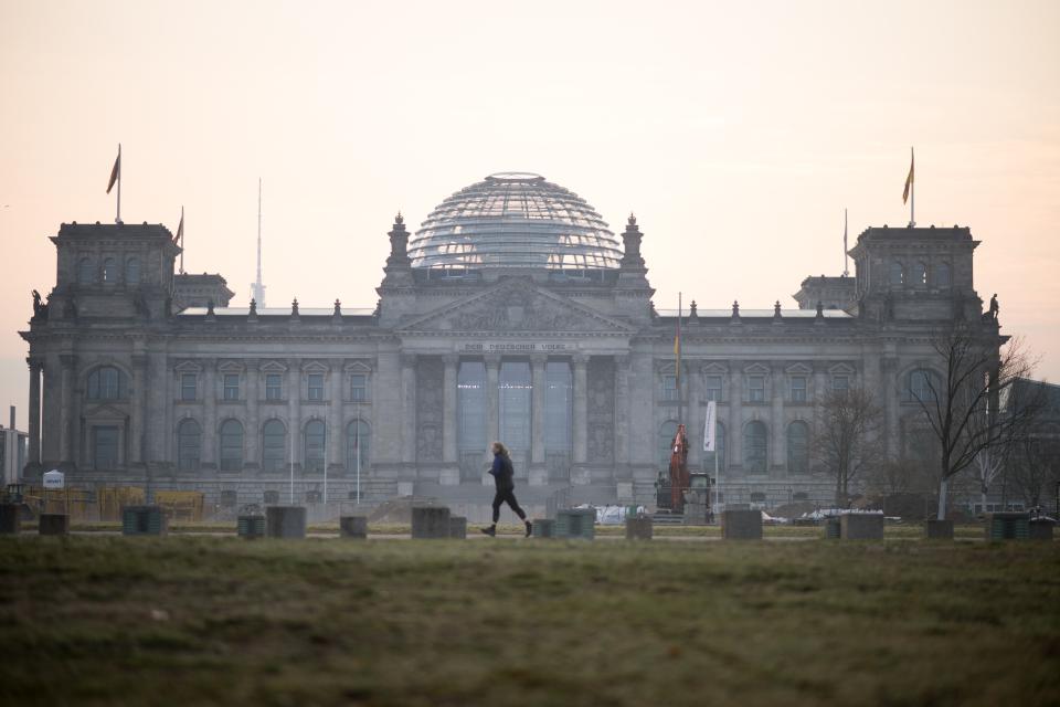 Eine Frau joggt am Tag der Konstituierenden Sitzung des 21. Deutschen Bundestages vor dem Reichstag