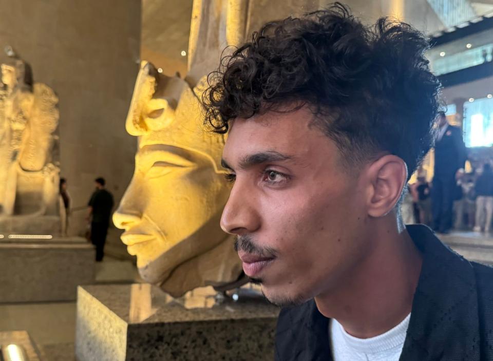 Der ägyptische Influencer Youssef Mohamed steht neben einer Büste des Pharaos Echnaton im Großen Ägyptischen Museum in Kairo