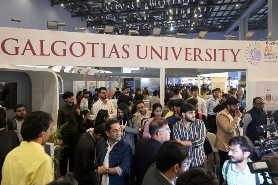 Menschen besuchen den Stand der Galgotias-Universität auf dem AI Impact Summit, bevor die indischen Behörden eine Räumung anordnen
