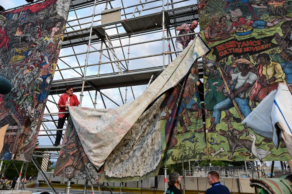 Documenta-Mitarbeiter bauen im Juni 2022 das umstrittene Großbanner "People's Justice" des indonesischen Künstlerkollektivs Taring Padi auf dem Friedrichsplatz ab