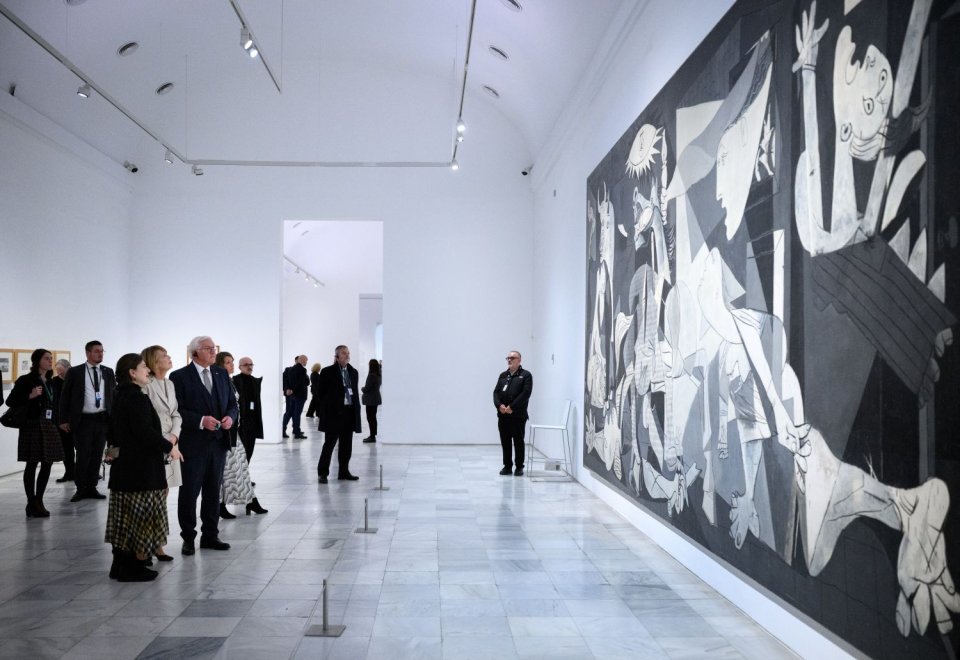 Installationsansicht: Picasso, Guernica, großformatiges Gemälde; Besuchergruppe betrachtet es.