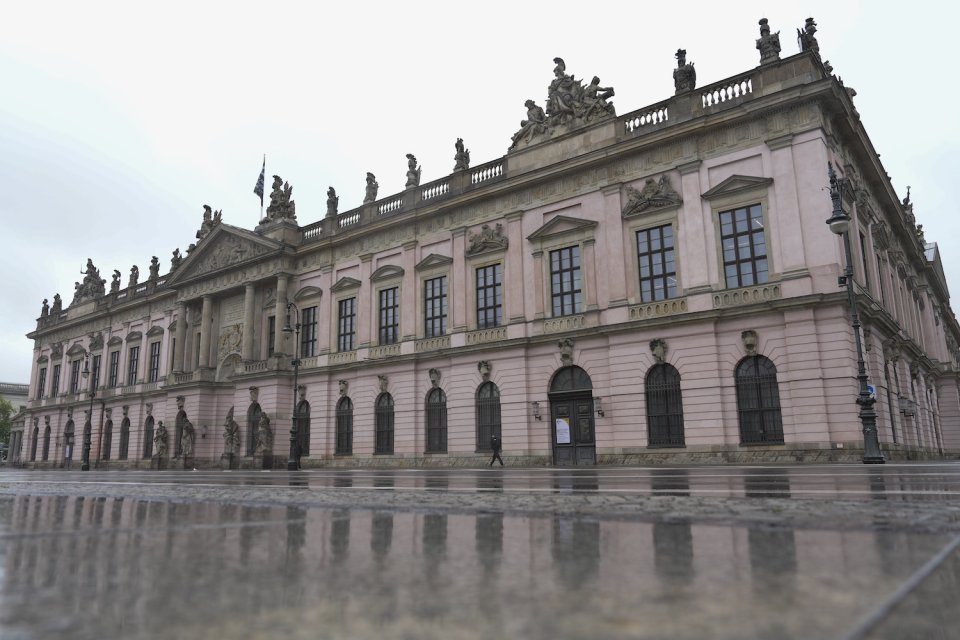 Foto, historische barocke Fassadenfront mit Dachskulpturen; nasser Vorplatz, Weitwinkel.