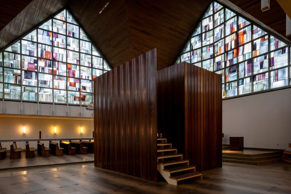 Installationsansicht Kirche: raumhoher kubischer Bau aus Metallplatten mit Treppe; Buntglasfenster
