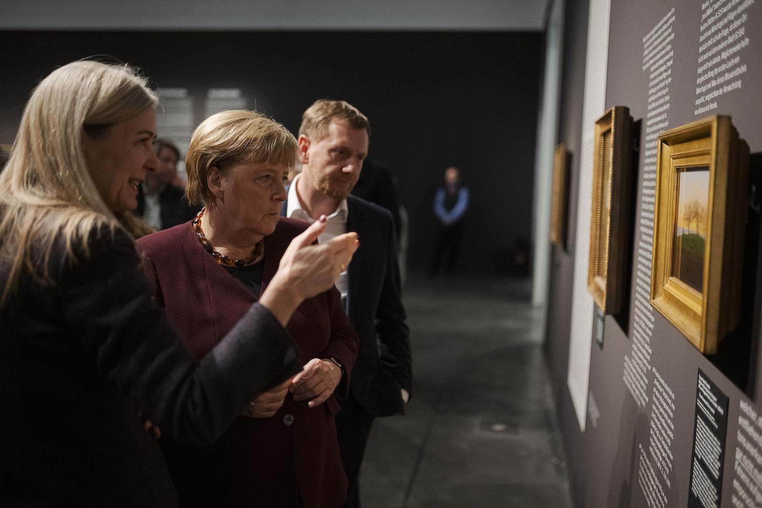 Sachsens Ministerpräsident Michael Kretschmer (l-r), Bundeskanzlerin a. D. Angela Merkel und Marion Ackermann, Generaldirektorin der Staatlichen Kunstsammlungen Dresden, beim Rundgang durch die Ausstellung "Caspar David Friedrich. Wo alles begann" im Albertinum Dresden