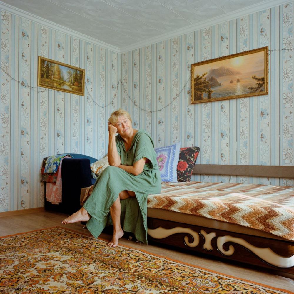 Nächste Seite: Sommer 2022. Schtscholkine, besetzte Krim. Larisa posiert in ihrer Wohnung in Schtscholkine. Sie zog 1978 in die Stadt und unterstützt wie viele andere Russen, die unter der Sowjetunion auf die Krim kamen, deren Annexion durch Russland