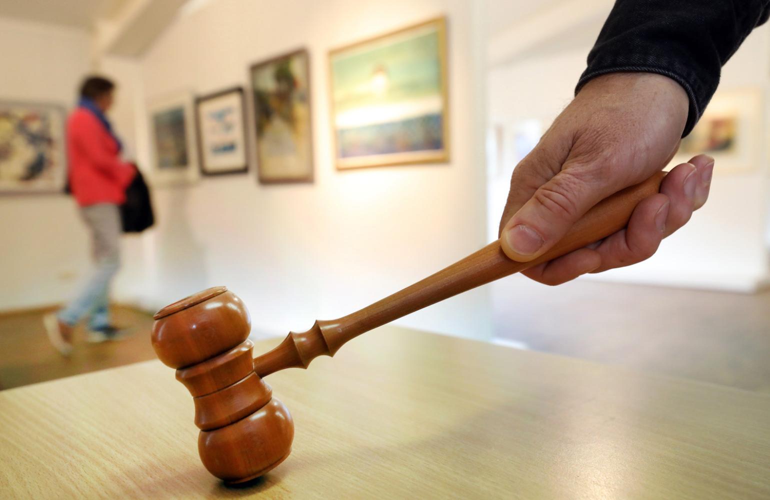 Auktionator Robert Dämmig zeigt seinen Auktionshammer in der Strandhalle Ahrenshoop