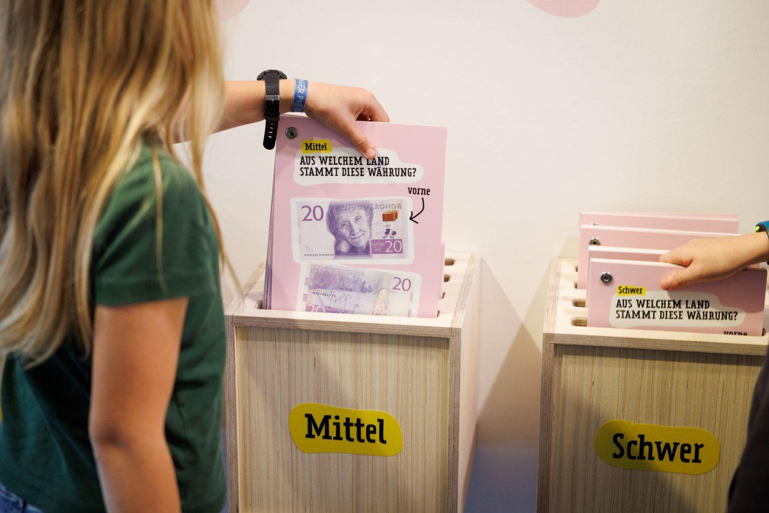 Kinder stehen vor einem Exponat in der Sonderausstellung "Von Kohle, Kröten und Moneten - eine Kinderausstellung über Geld" im Museum für Industriekultur Osnabrück