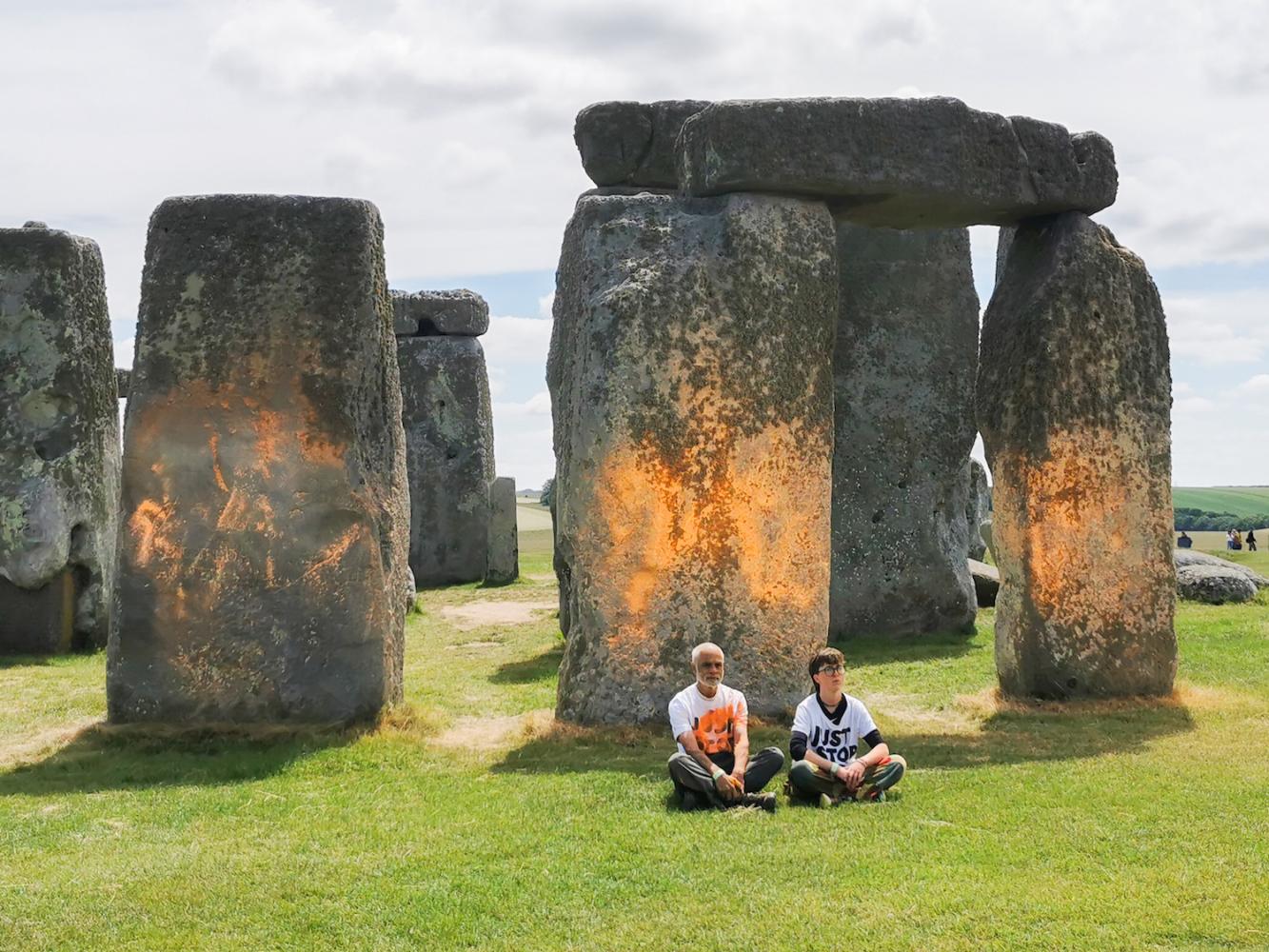 as Videostandbild zeigt Demonstranten von «Just Stop Oil», die eine orangefarbene Substanz auf Stonehenge gesprüht haben