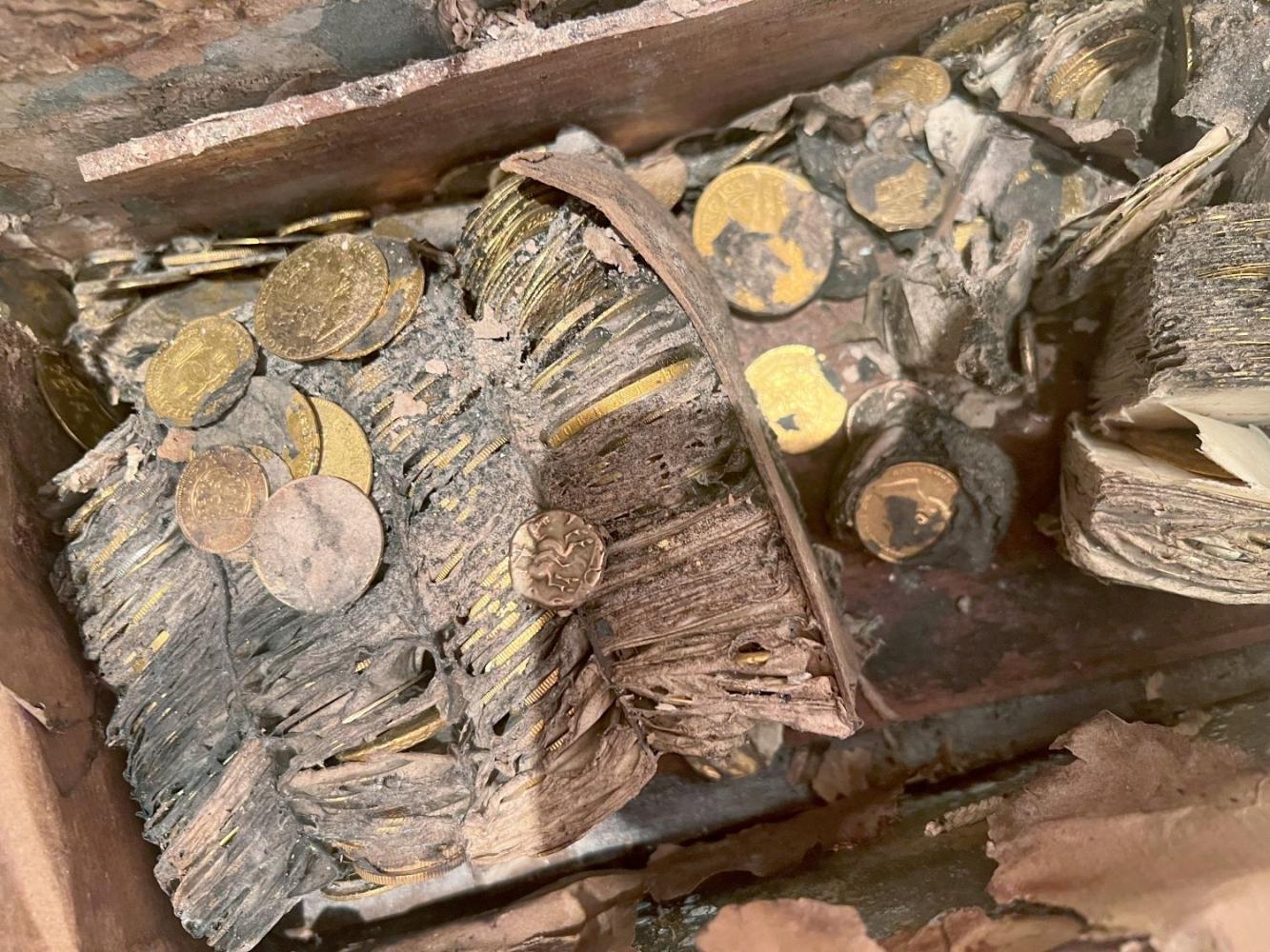 Blick in die Kiste, in der tausende Goldmünzen in Tütchen verpackt jahrzehntelang in einem Garten in Europa vergraben waren