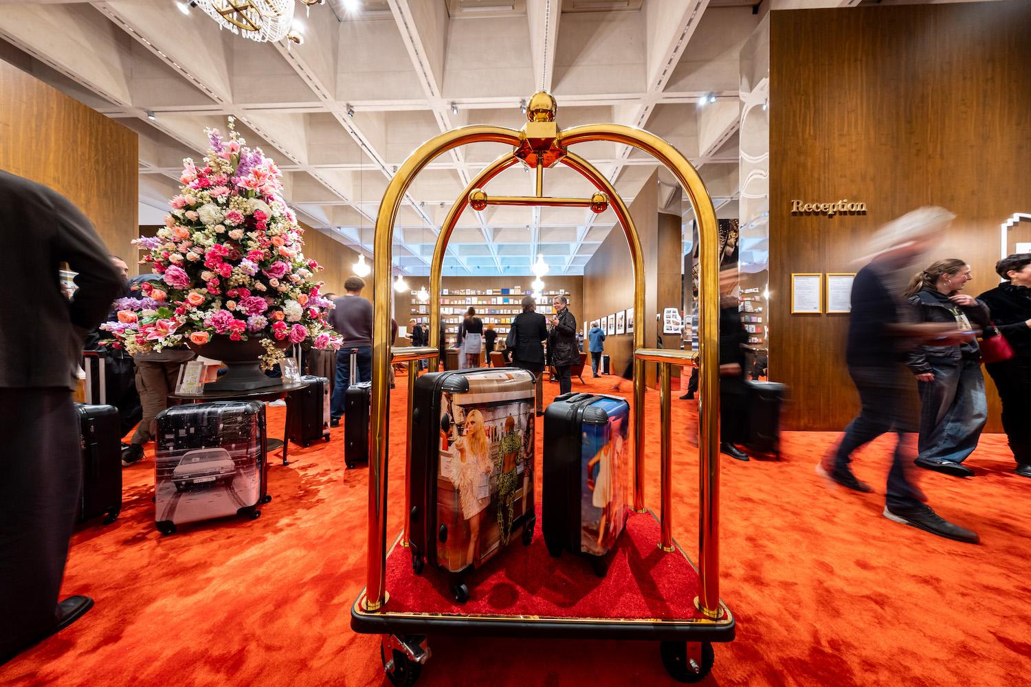Ein Kofferwagen mit Trolleys, die mit Motiven des britischen Magnum-Fotografen Martin Parr bedruckt sind, steht in der Ausstellung „Grand Hotel Parr – Fotobücher von Martin Parr“ im Neuen Museum Nürnberg