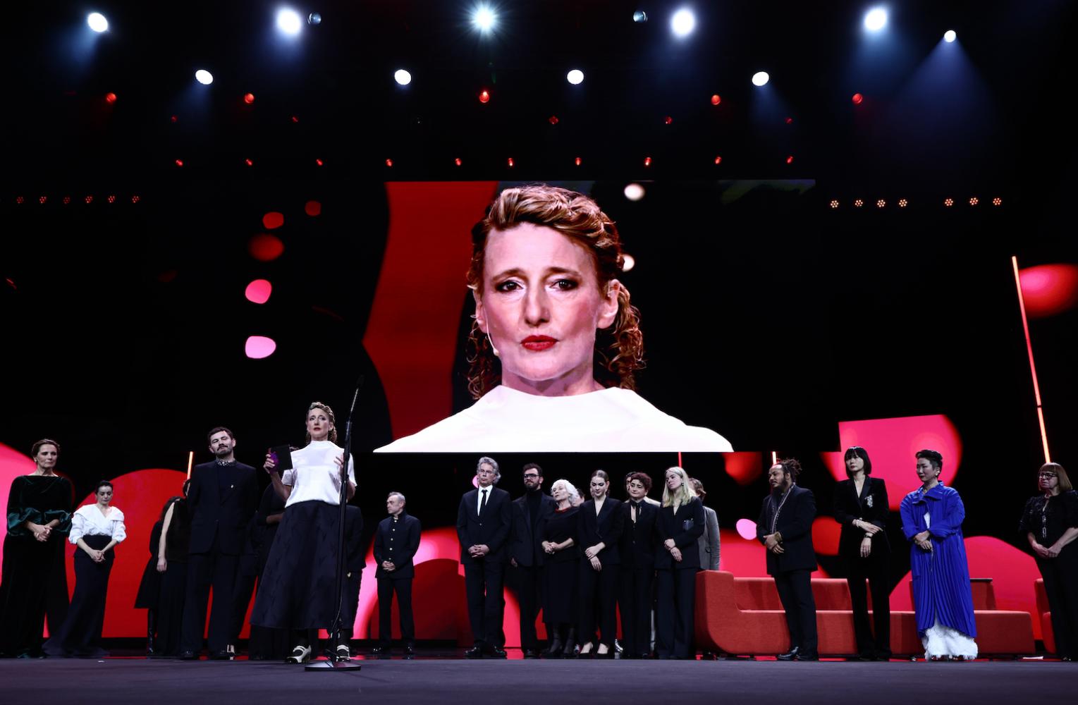 Tricia Tuttle (M) steht mit Preisträgern und Jurymitgliedern während der Preisverleihung bei der Abschlussgala im Berlinale Palast auf der Bühne