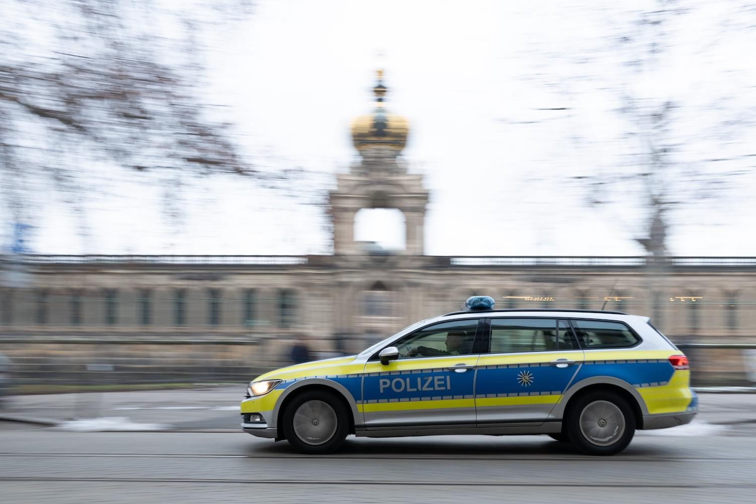 Ein Polizeiauto fährt vor dem Kronentor des Dresdner Zwingers entlang