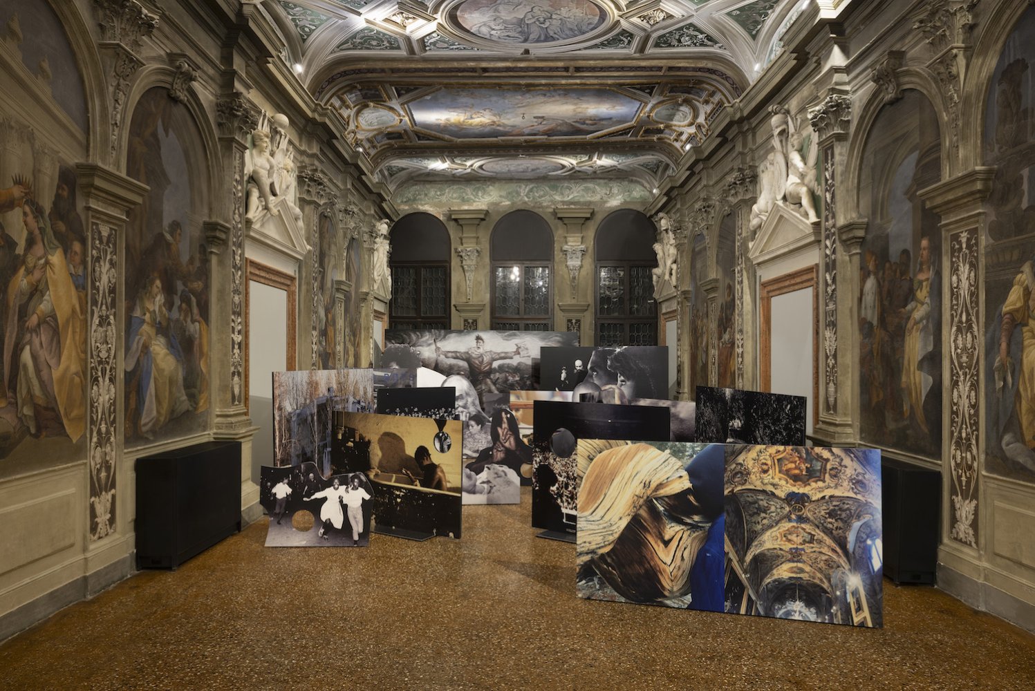 Installationsansicht: freistehende, gestaffelte großformatige Fotopaneele in barockem Freskosaal.