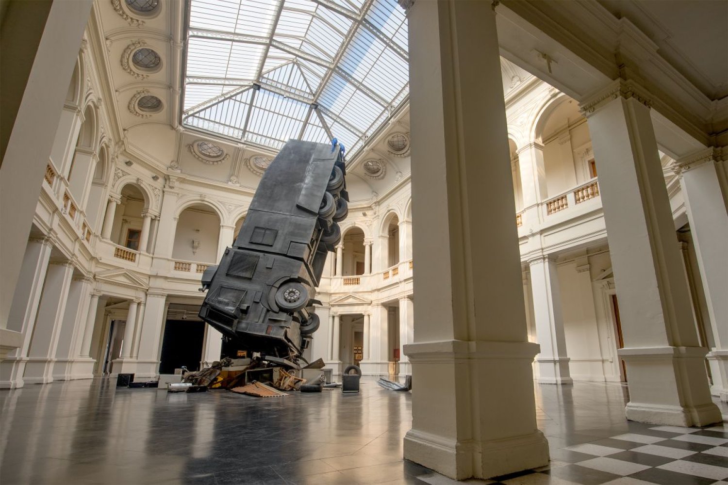 Großinstallation: Buswrack schräg aufragend im Museumsatrium mit Glasdach.