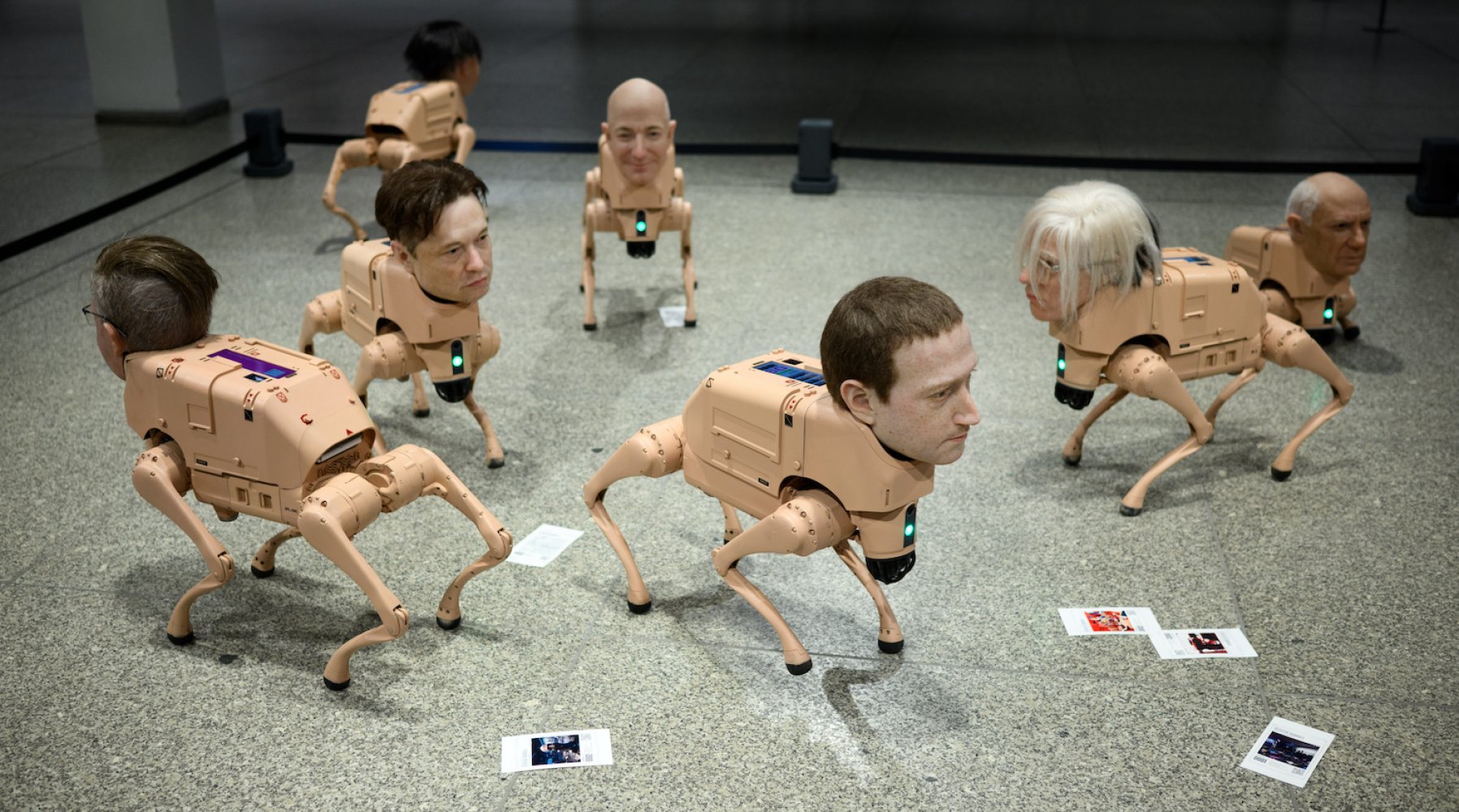 Installationsansicht: mehrere kniehohe vierbeinige Skulpturen mit menschlichen Köpfen; Bodenfotos