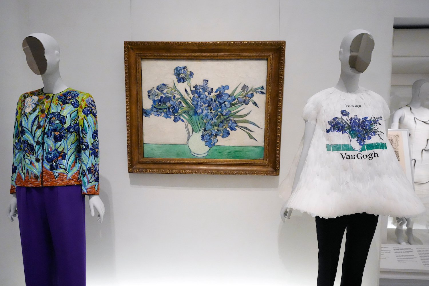 Installationsansicht: Van Gogh, Iris-Stillleben, Öl; zwei Modepuppen flankieren das Werk.