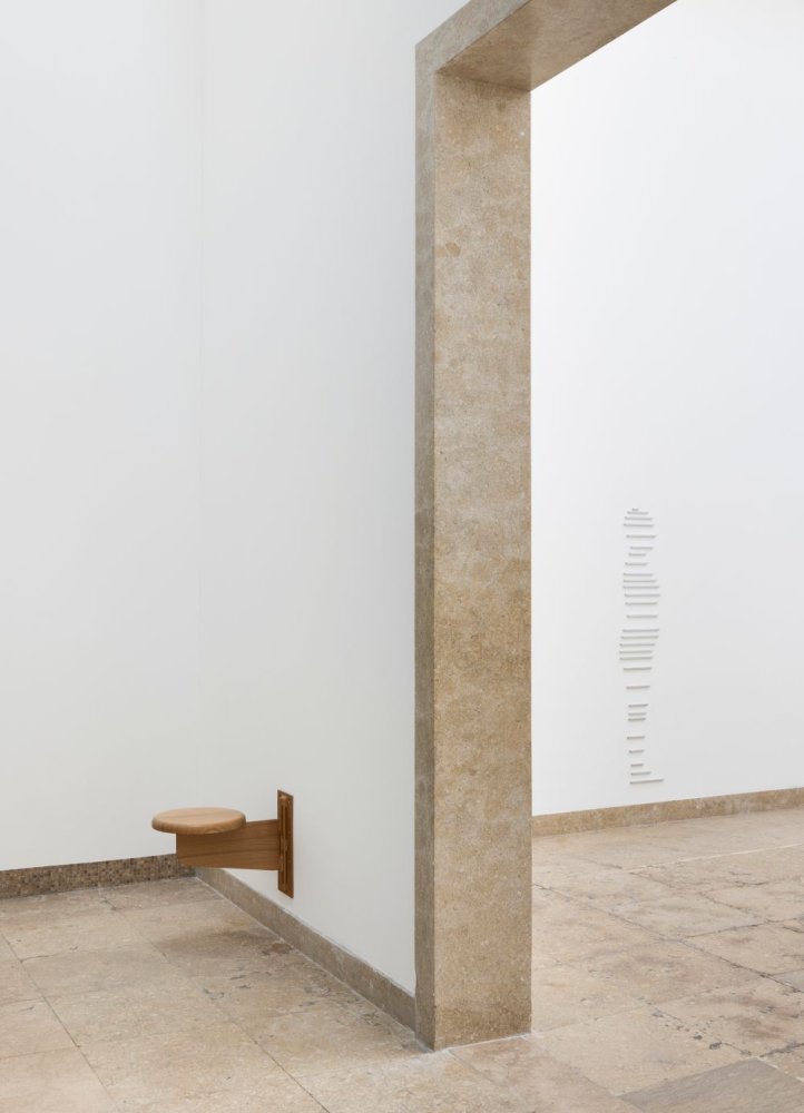 Sung Tieu, Installationsansicht Deutscher Pavillon: Wandsitz an Ecke, Steinrahmen, Wandmarken.